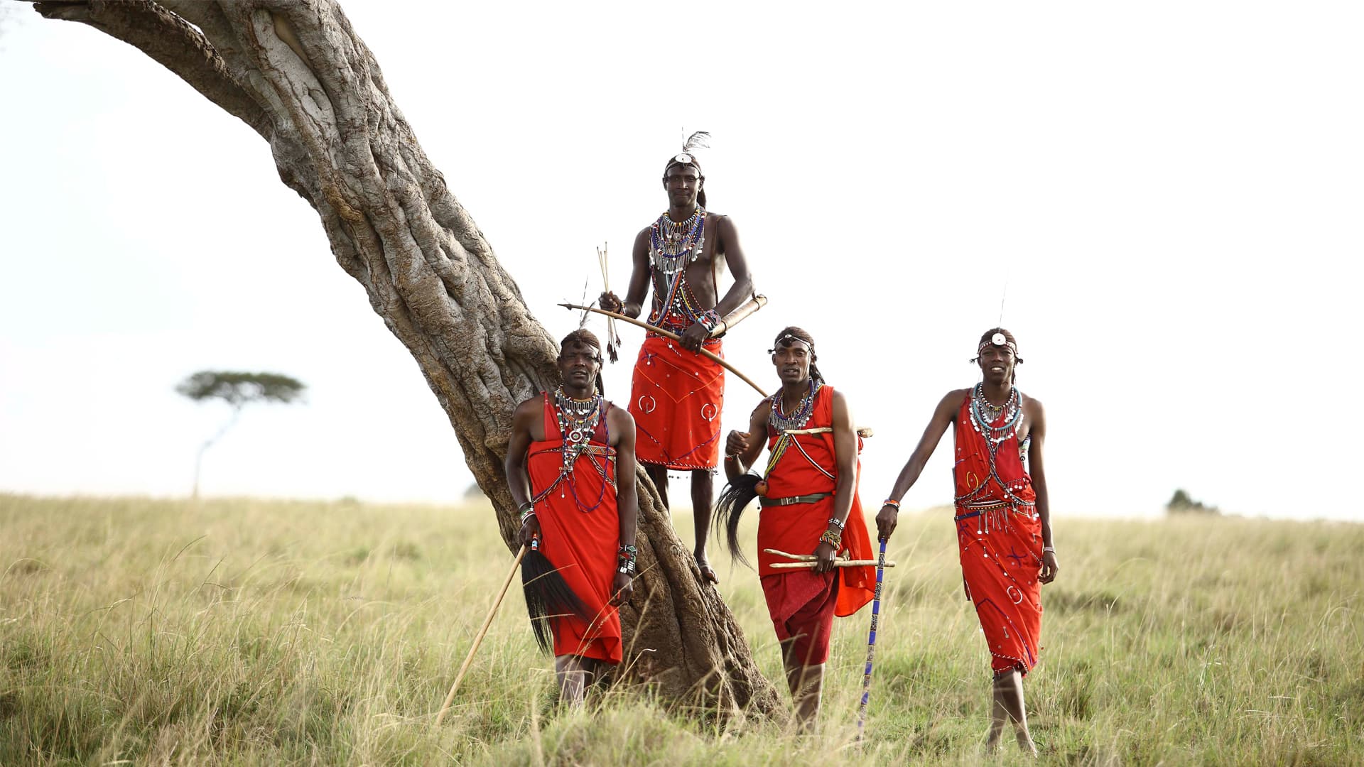 Maasai men standing by a tree in the Masai Mara